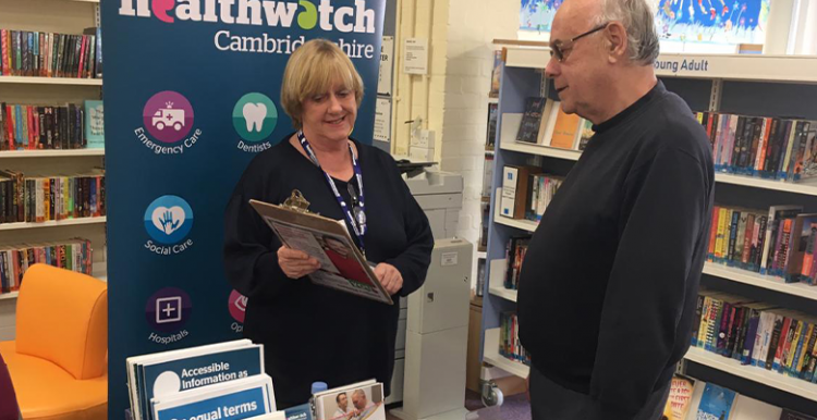 Healthwatch volunteer Pam listening to a member of the public in a library