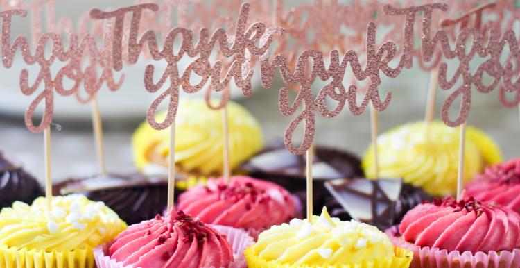 A collection of brightly coloured cup cakes with Thank you messages on them