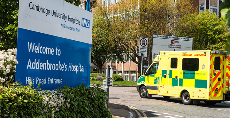 Entrance to Cambridge University Hospitals with ambulance driving in