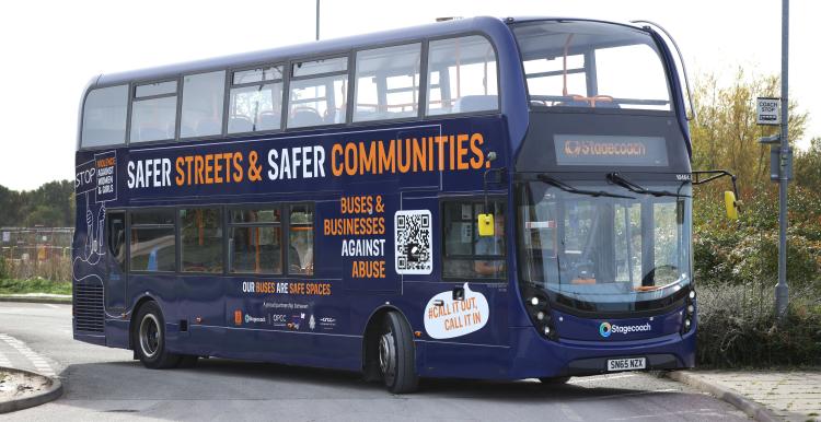 Double decker bus with Safer Streets and Safer Communities campaign message written on its side