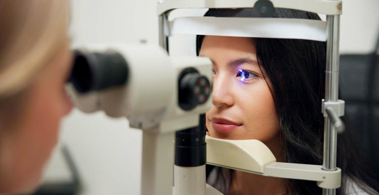 A woman having her eyes scanned by an optician