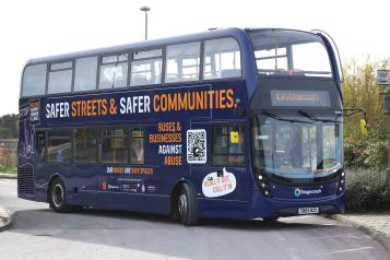 Double decker bus with Safer Streets and Safer Communities campaign message written on its side