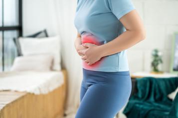 A woman clutching a hot water bottle to her stomach