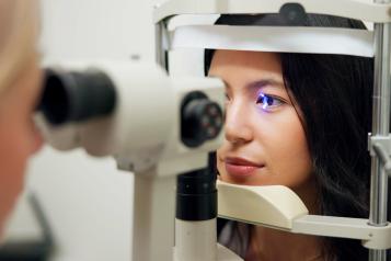 A woman having her eyes scanned by an optician