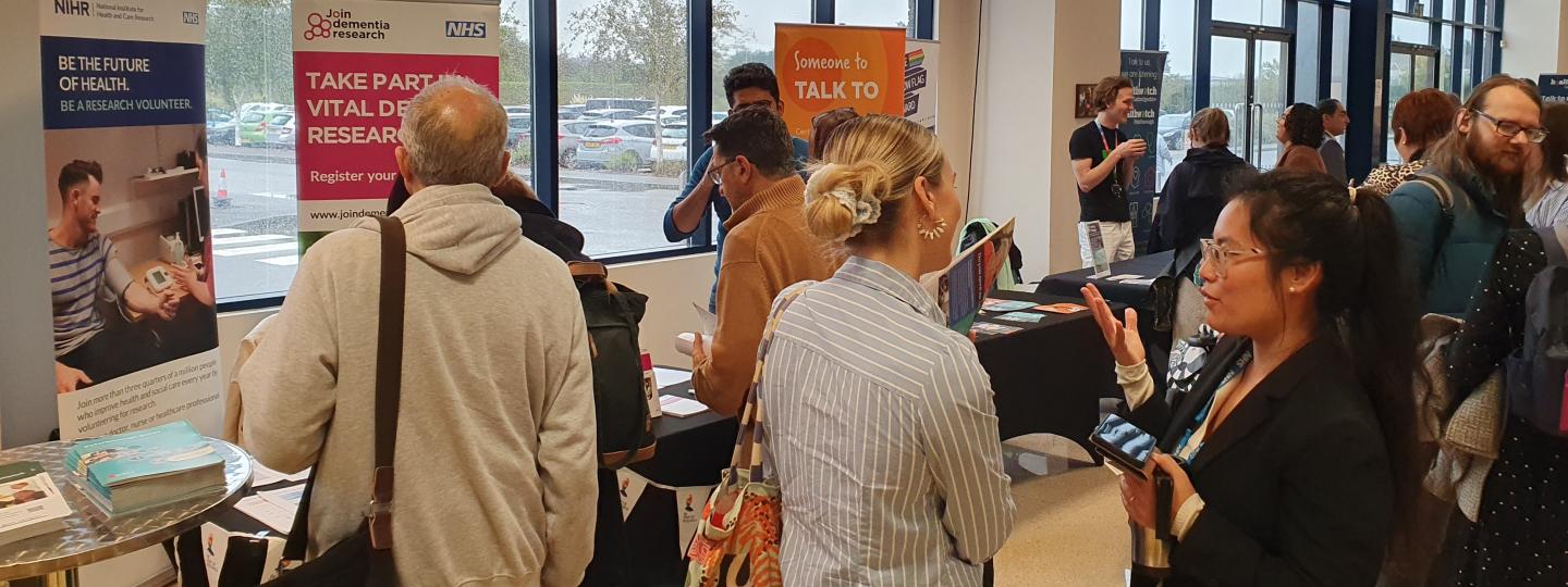 Delegates gather at the Summit event. People are talking to each other or visiting stands in the background.